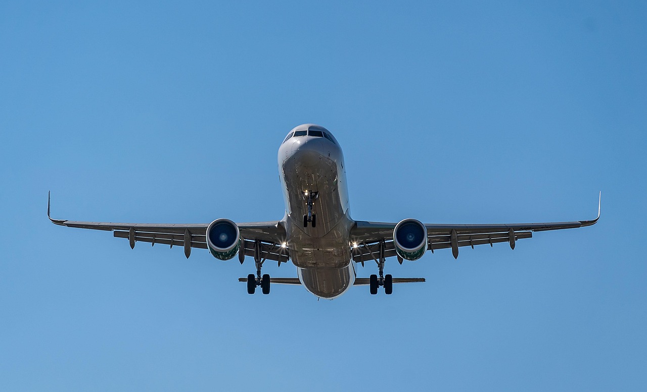 Avión despegando al atardecer, símbolo de las conexiones aéreas con la Hospedería de la Corte desde Sevilla, Faro y Lisboa.