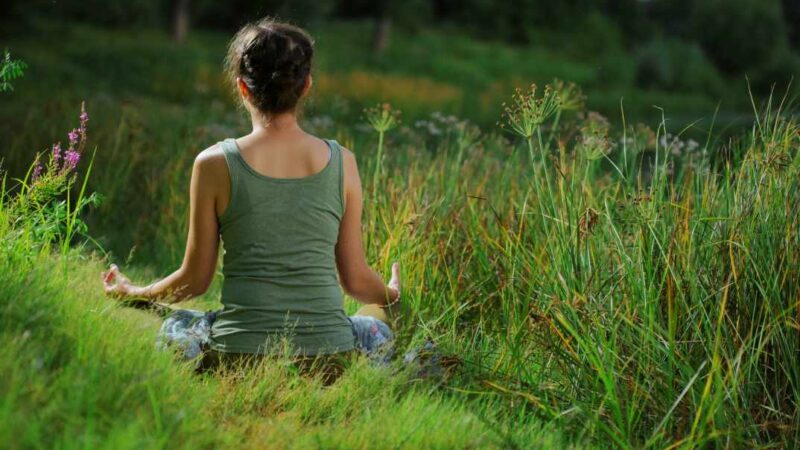 Mujer meditando al aire libre en la Sierra de Aracena – Hospedería de la Corte