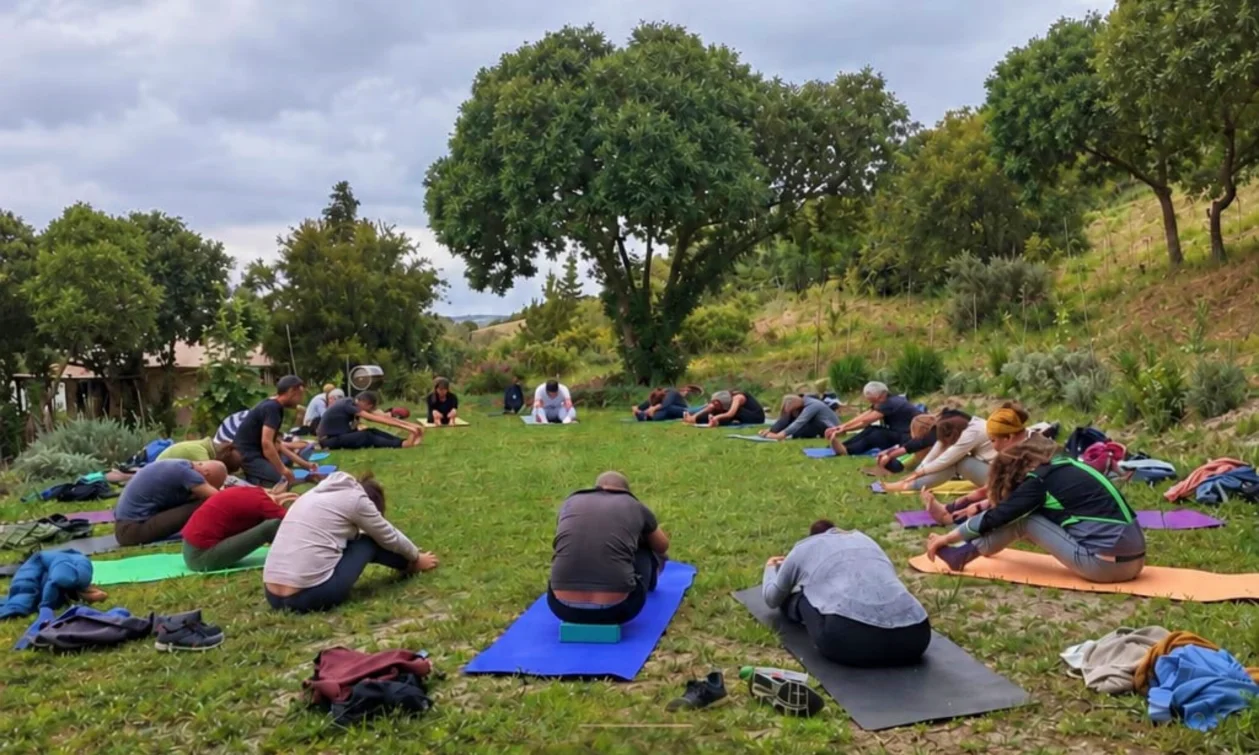 Nirodha Invernal, retiro de yoga en Sierra de Aracena, con grupo practicando yoga bajo encinas